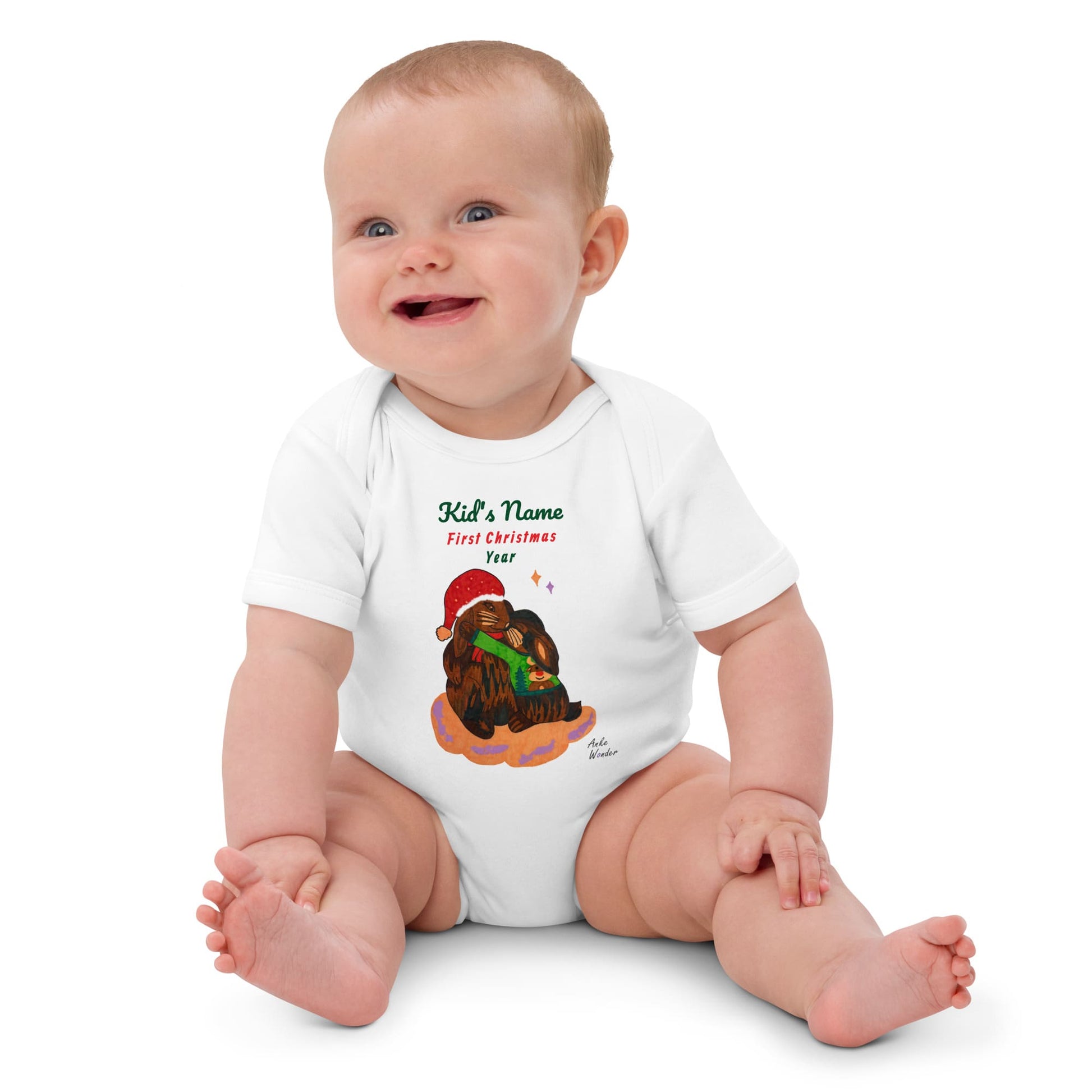 Baby girl wearing a white onesie with a Christmas rabbit design and text 'First Christmas'