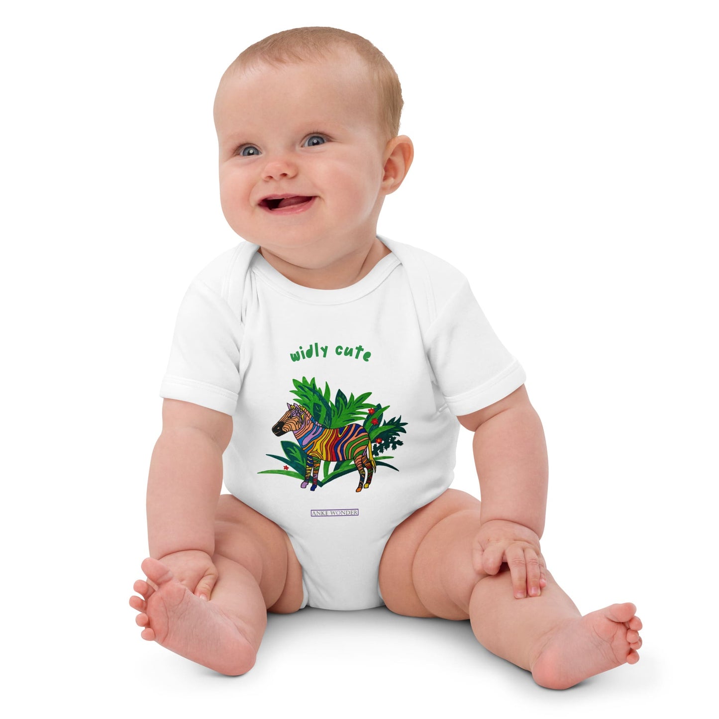 Baby girl wearing a white onesie with a colorful zebra design and text 'widly cute' on a white background