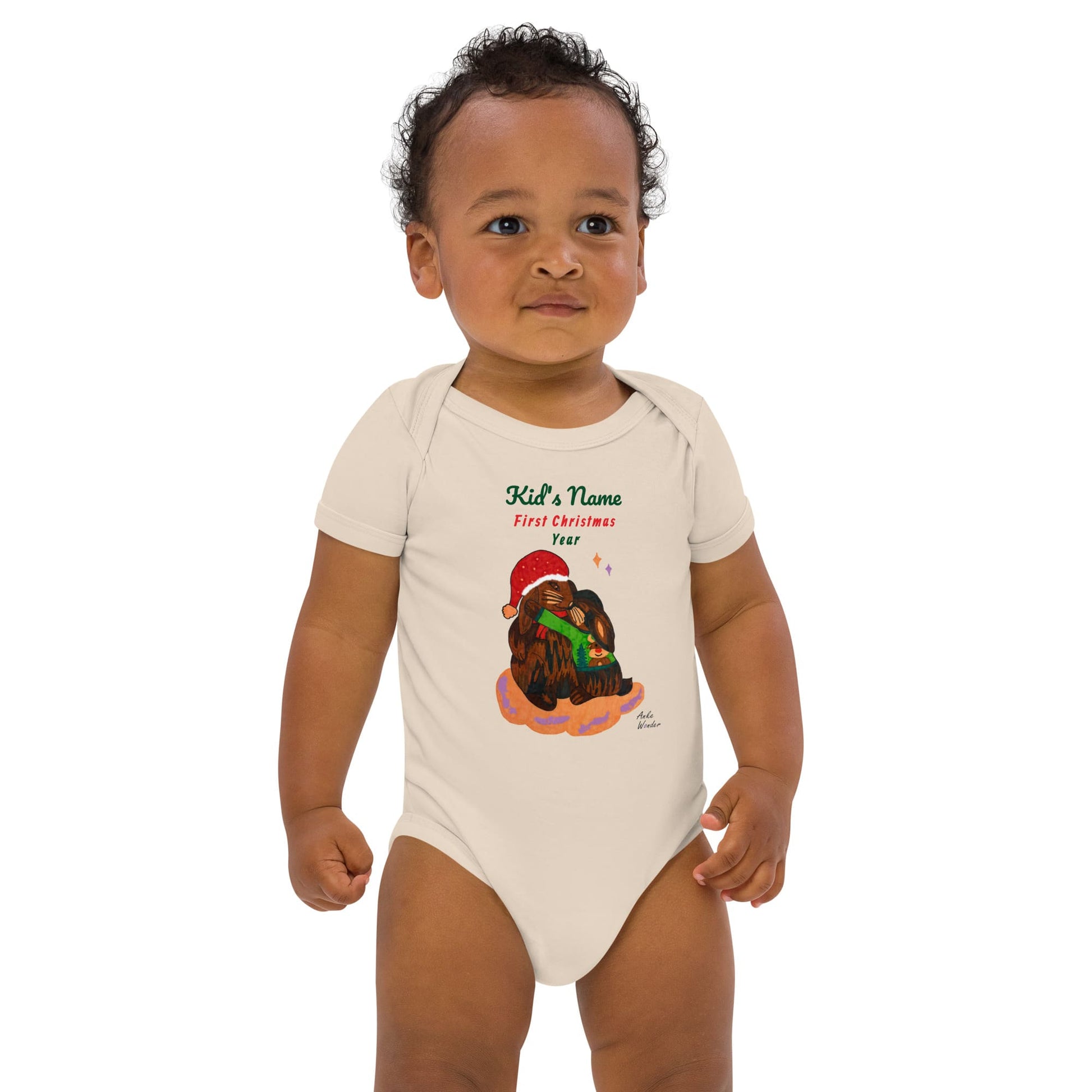Baby Boy wearing a beige onesie with a Christmas design and 'First Christmas' text on a white background