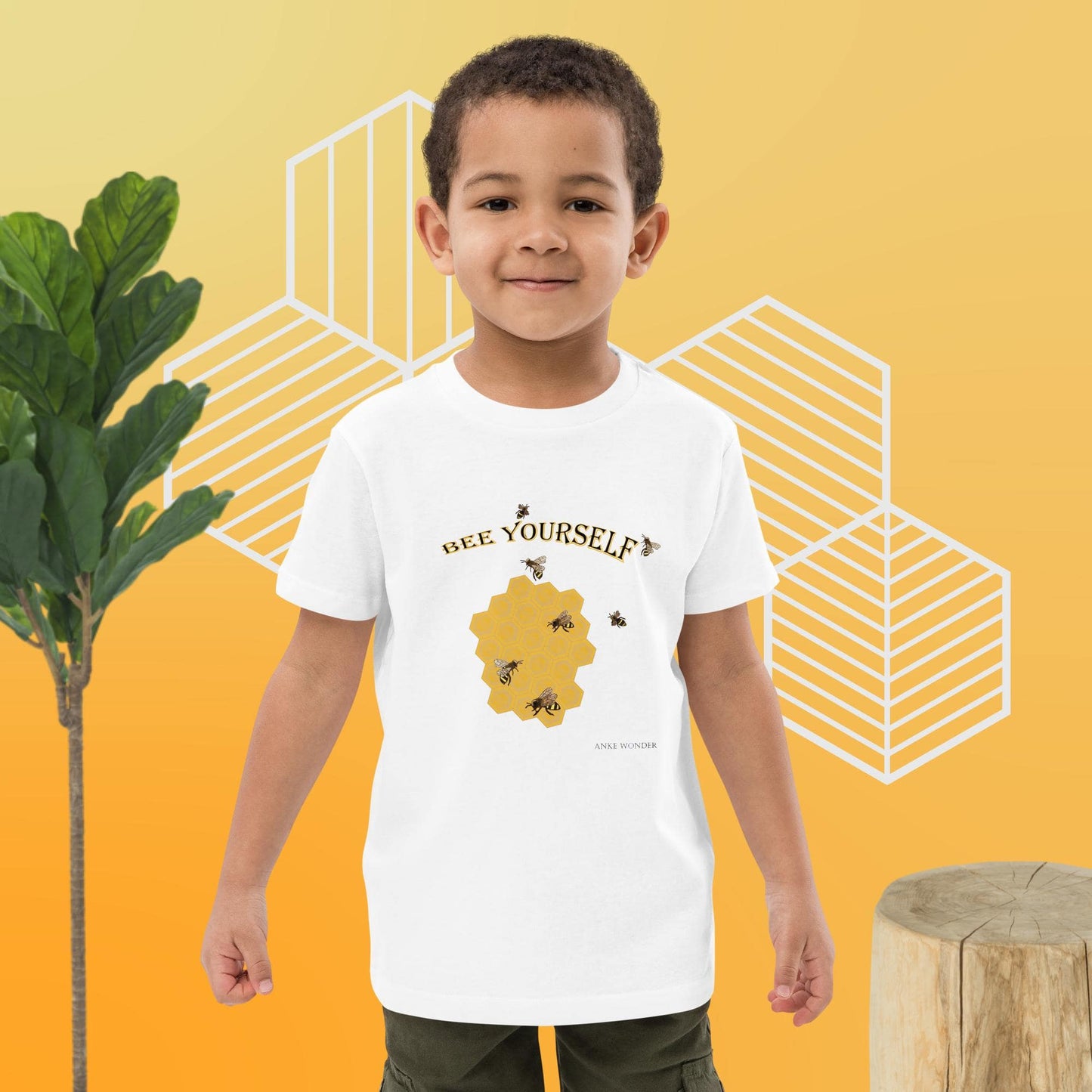 Boy wearing a white t-shirt with a 'Bee Yourself' design on a yellow background