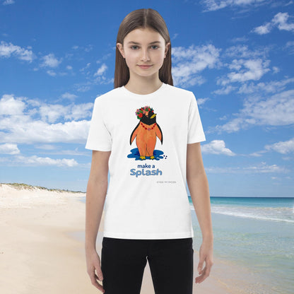 Girl wearing a white t-shirt with a penguin graphic and 'make a splash' text on a beach.