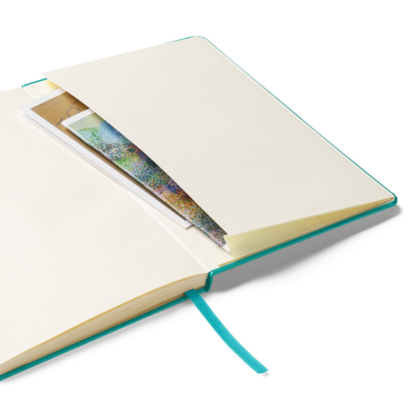Open turquoise notebook with view of the inside pocket on a white background by Anke Wonder.