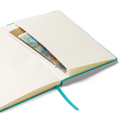 Open turquoise notebook with view of the inside pocket on a white background by Anke Wonder.