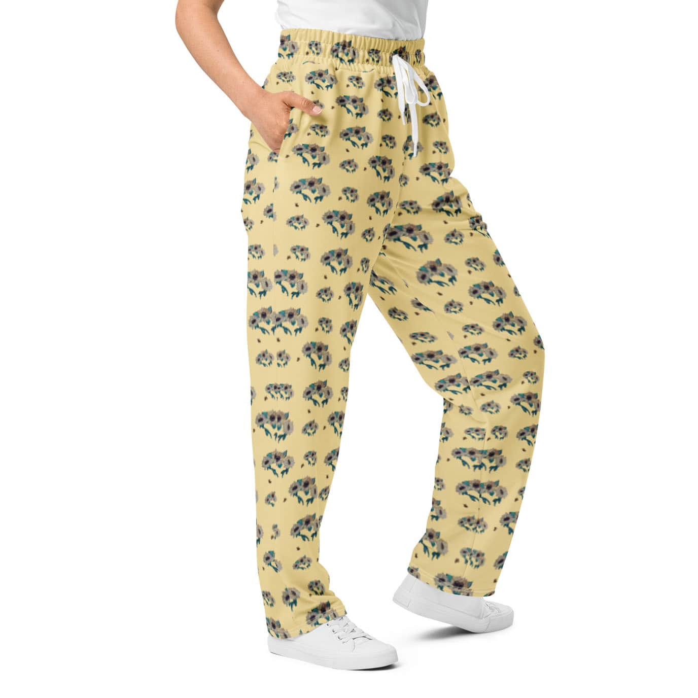Yellow floral sunflower pants worn by a woman on a white background