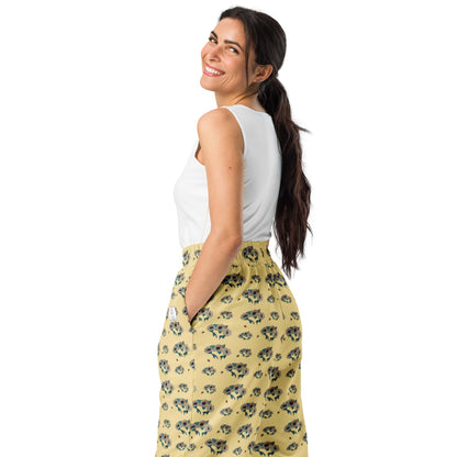 Woman wearing a white top and yellow floral pants on a white background