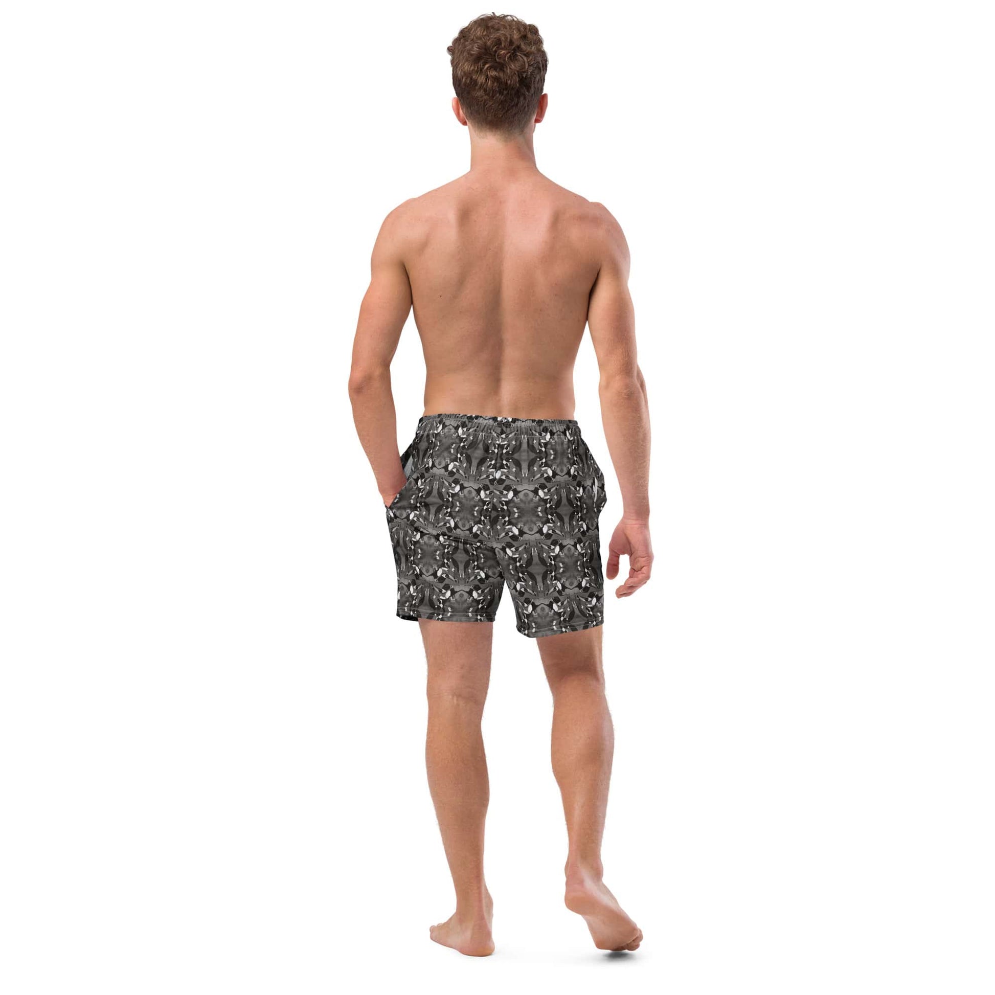Back view of men’s black and white swim trunks made from recycled polyester. Displays mirrored bird pattern and sustainable swimwear fit.