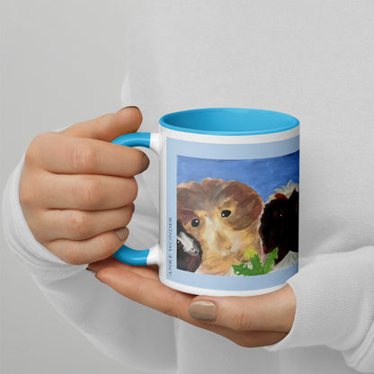 A person in a white long-sleeve shirt holds a white ceramic mug with a bright blue handle and interior. The mug features a printed illustration of a guinea pig on the front.