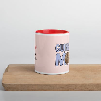 Side view of personalized Guinea Pig Mom ceramic mug featuring a cute brown and white guinea pig illustration with red handle and red interior, held in hands.