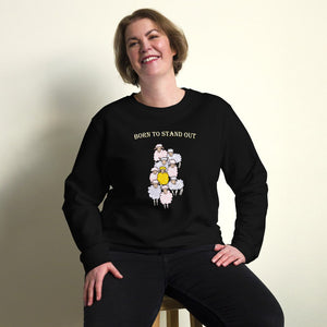 A woman wearing a black organic cotton sweatshirt with a design of a yellow sheep among white sheep and the text "Born to Stand Out.