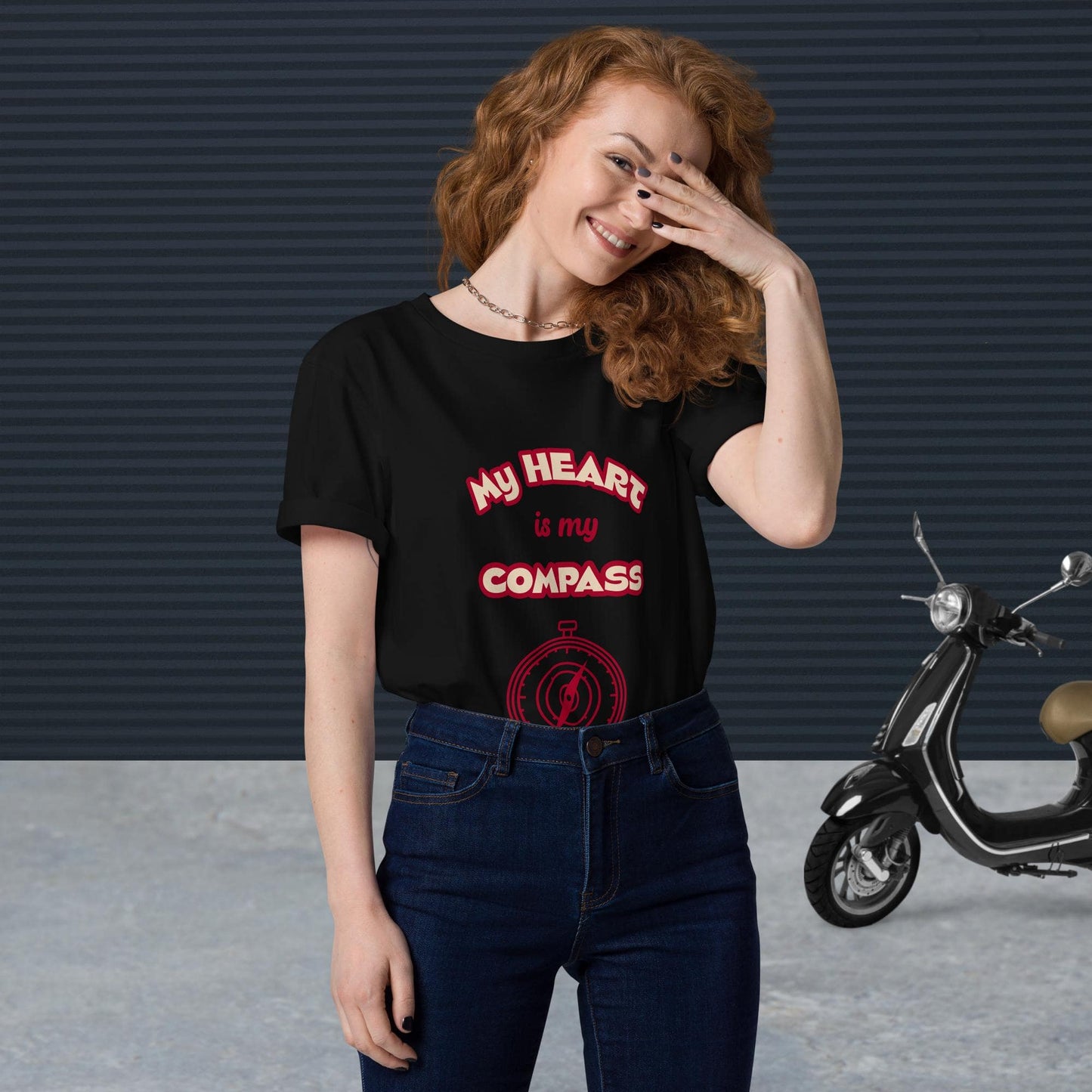 Front view of woman wearing tucked-in black organic cotton t-shirt with red 'My Heart is My Compass' design — stylish and sustainable spiritual clothing.