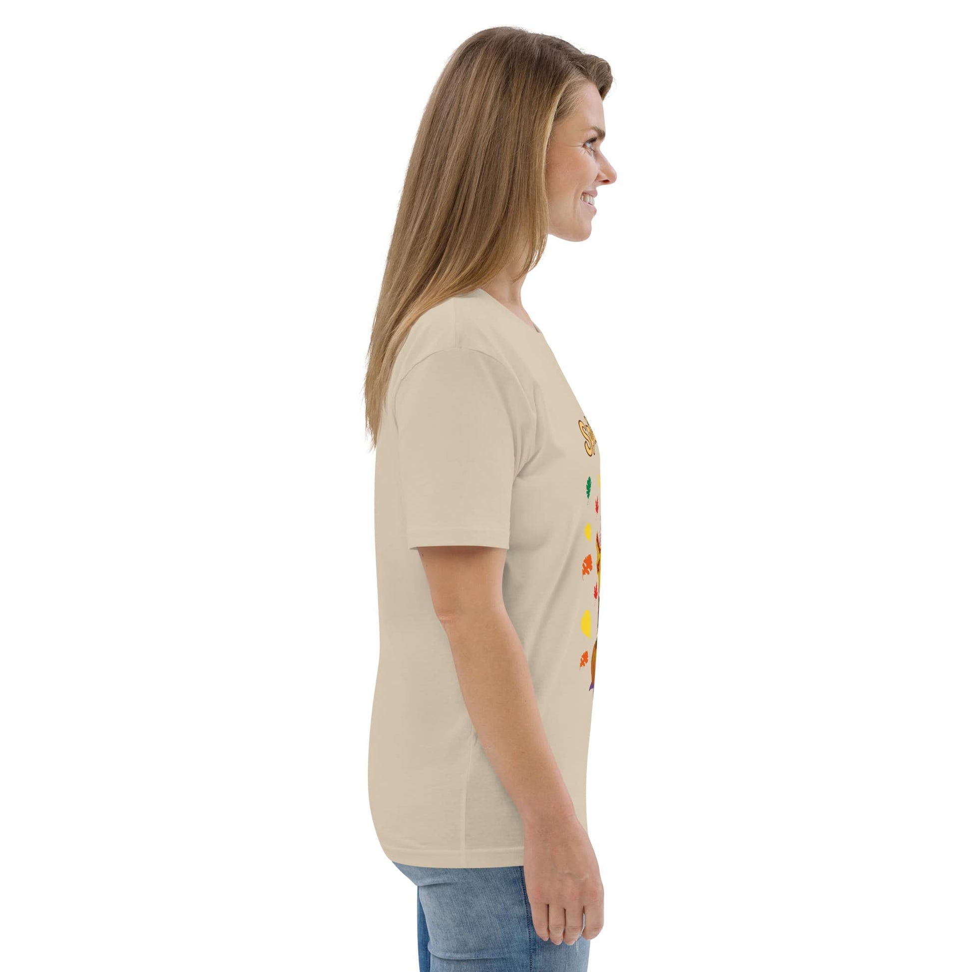 Side view of woman wearing a beige t-shirt with colorful graphics on a white background