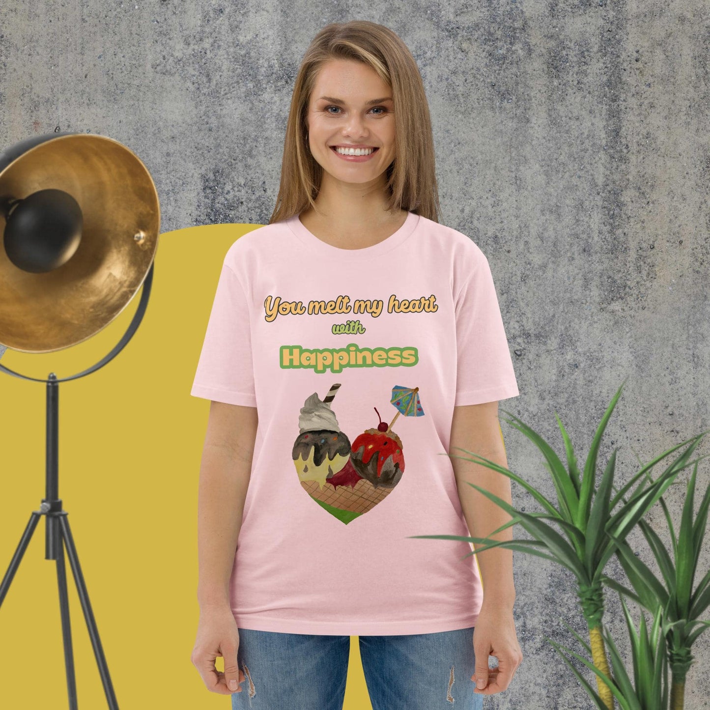 Woman wearing pink organic cotton t-shirt with colorful ice cream heart design and the phrase “You melt my heart with Happiness” by Anke Wonder.