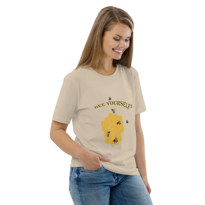 Woman wearing a beige t-shirt with a graphic of a beecomb and with the words 'Bee Yourself' on a white background