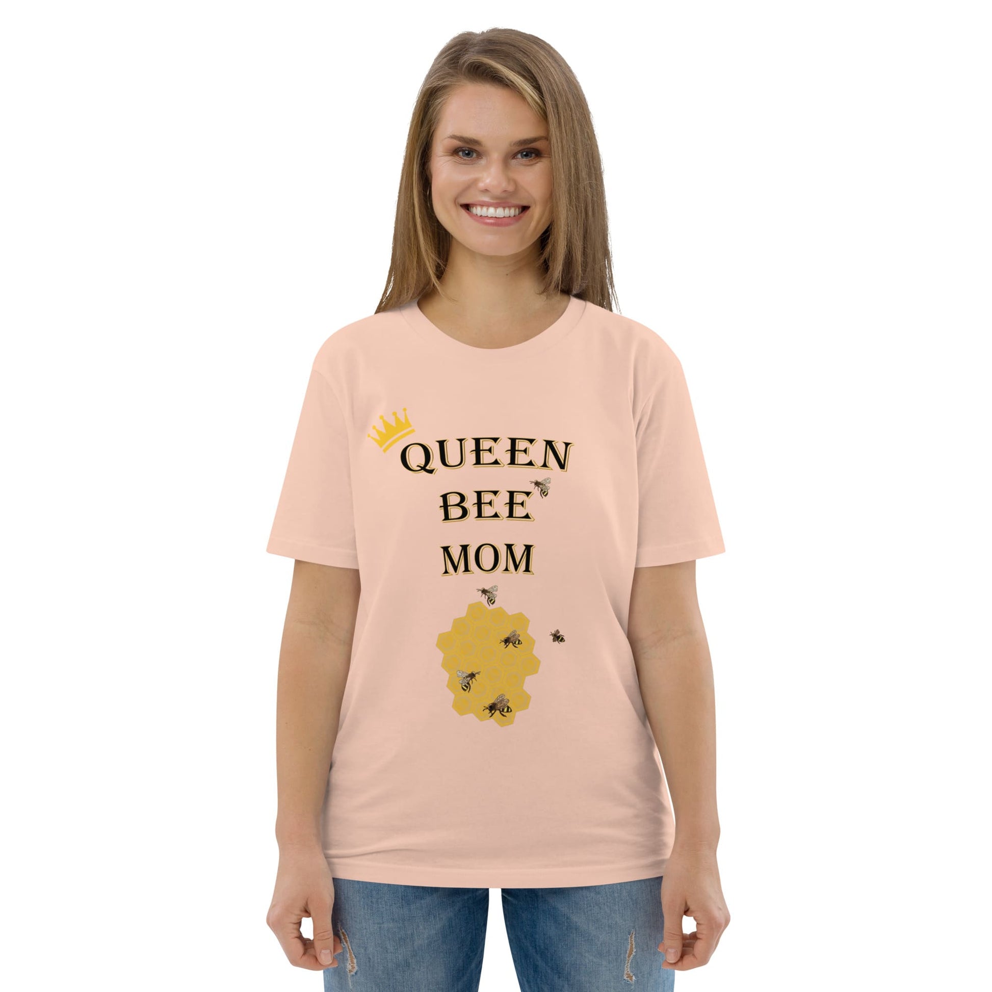 Woman wearing peach Queen Bee Mom organic cotton t-shirt, smiling, front view.