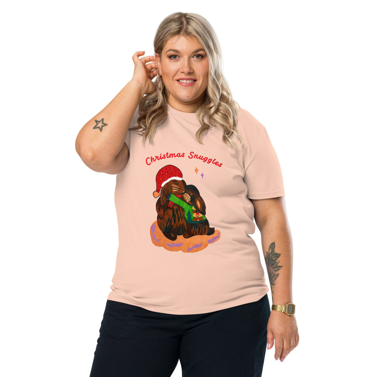 Woman wearing a peach t-shirt with a Christmas-themed rabbit graphic and teyt 'Christmas snuggles' on a white background