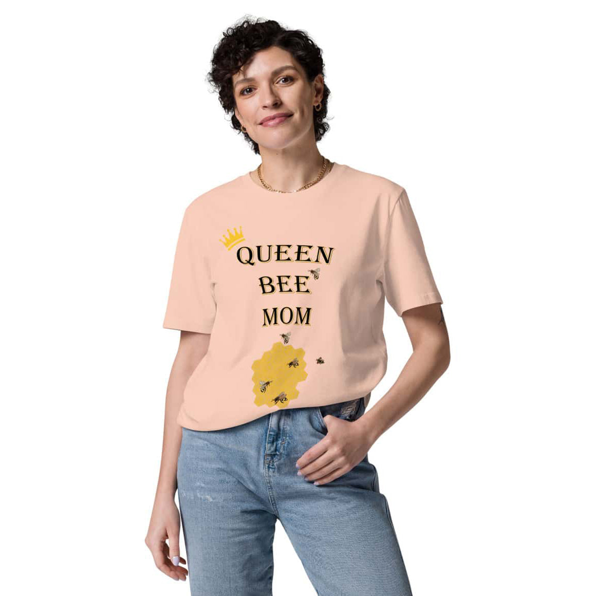 Woman wearing Queen Bee Mom peach t-shirt tucked into jeans, front view, casual and stylish look.