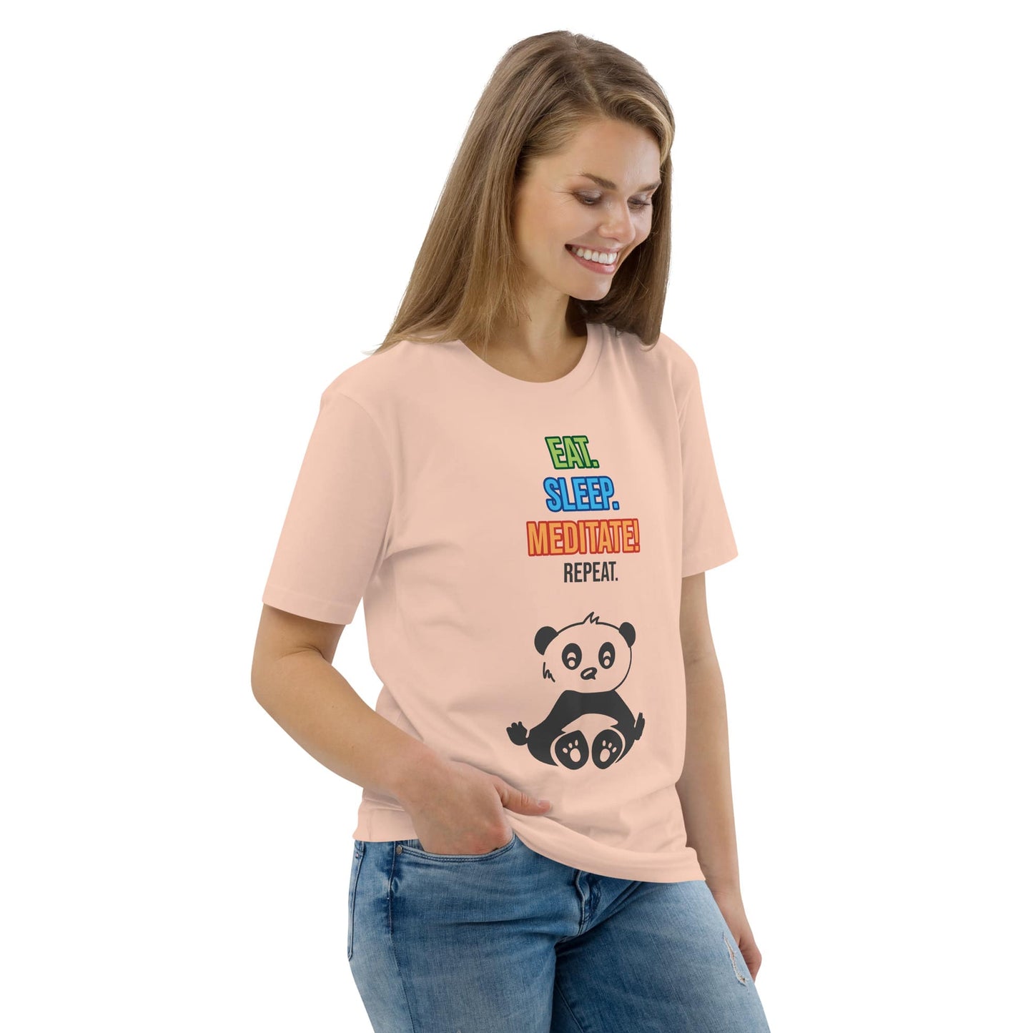 Woman wearing an organic cotton t-shirt in peach, photographed from the front at a right angle. The shirt features a playful panda and the text “Eat. Sleep. Meditate! Repeat.” Her relaxed pose highlights the comfortable fit and the soft drape of the fabric.