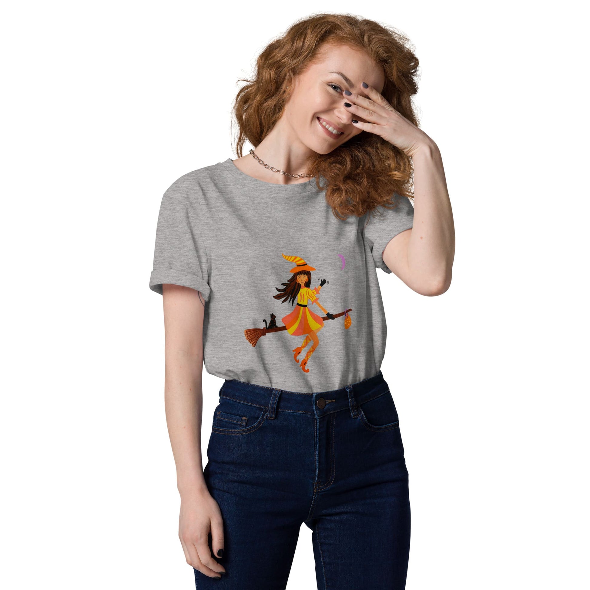Woman wearing a gray t-shirt with a halloween witch design on a white background
