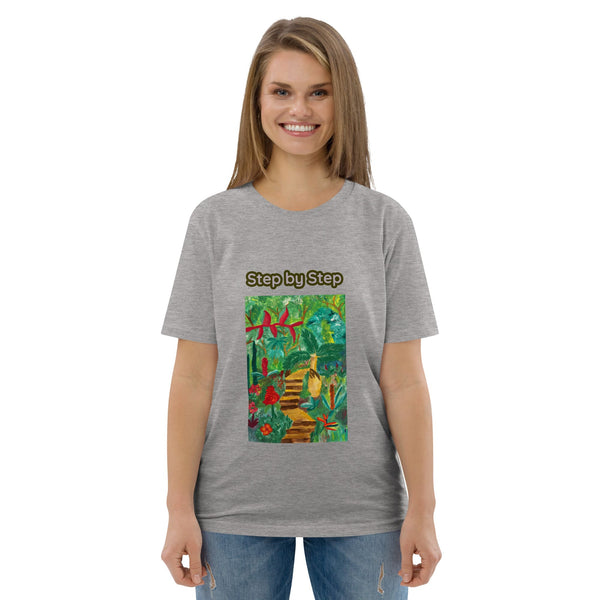 Woman wearing a gray t-shirt with a colorful graphic of the tropics and 'Step by Step' text on a white background