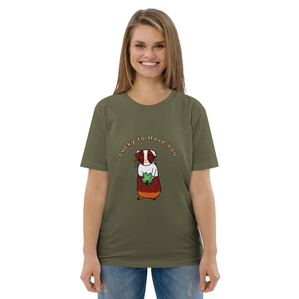 Woman wearing a green khaki organic cotton t-shirt featuring a brown and white guinea pig holding a shamrock, with the text "Lucky to Have You" curved above the design.