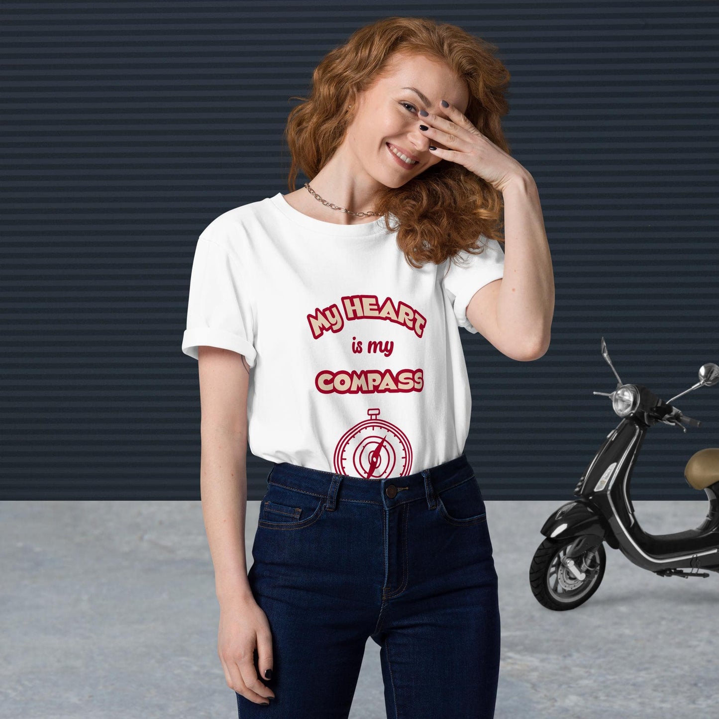 Front view of woman wearing tucked-in white organic cotton t-shirt with red 'My Heart is My Compass' design — stylish and sustainable spiritual clothing.