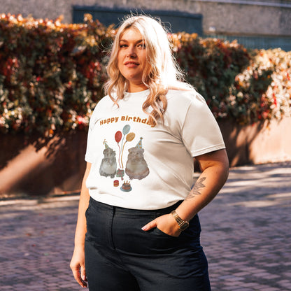 Side view of woman wearing a white t-shirt with a with guinea pig drawing and text 'Happy Birthday' outdoors