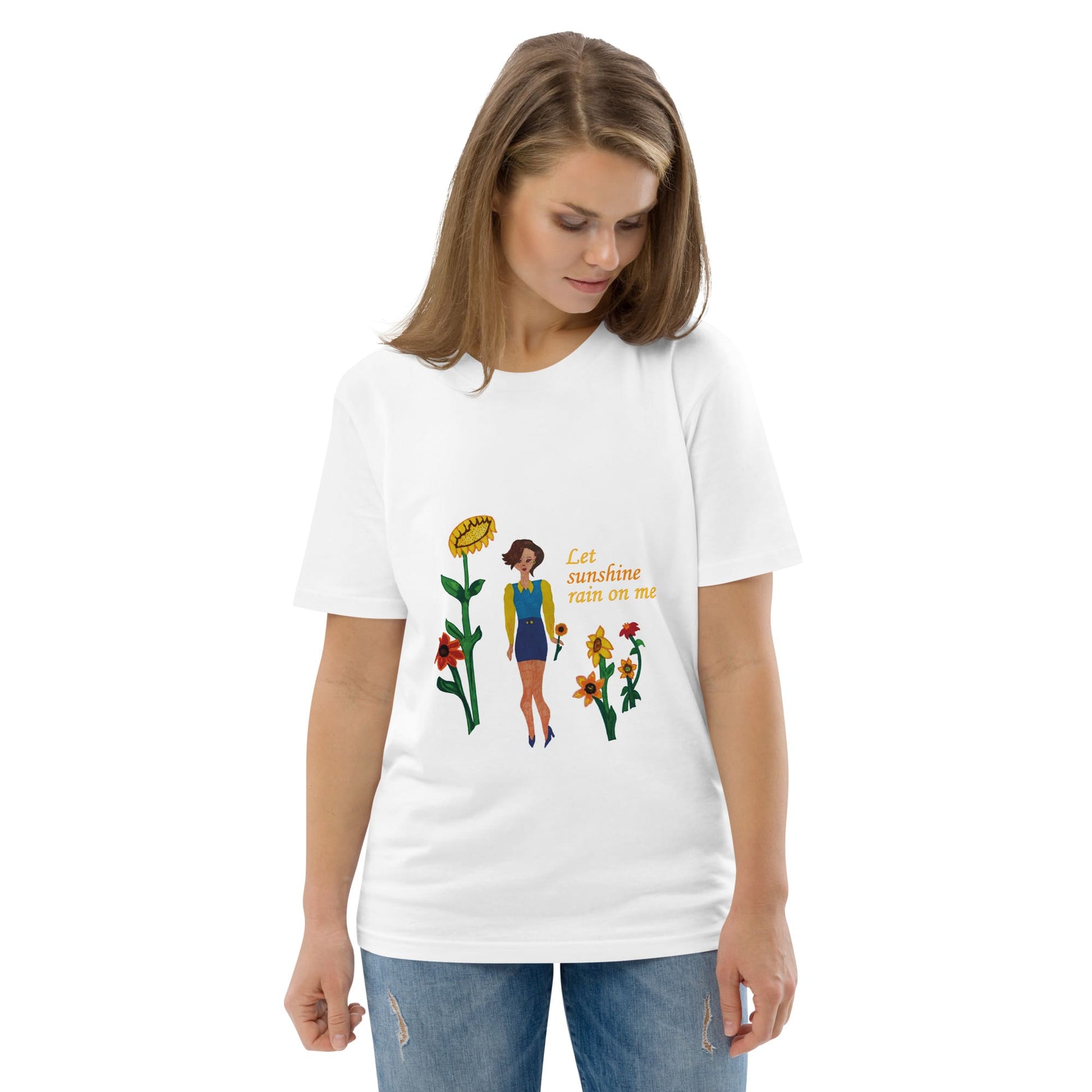 Woman wearing a white t-shirt with a colorful graphic design of sunflowers and a lady and the text 'Let sunshine rain on me' on a white background