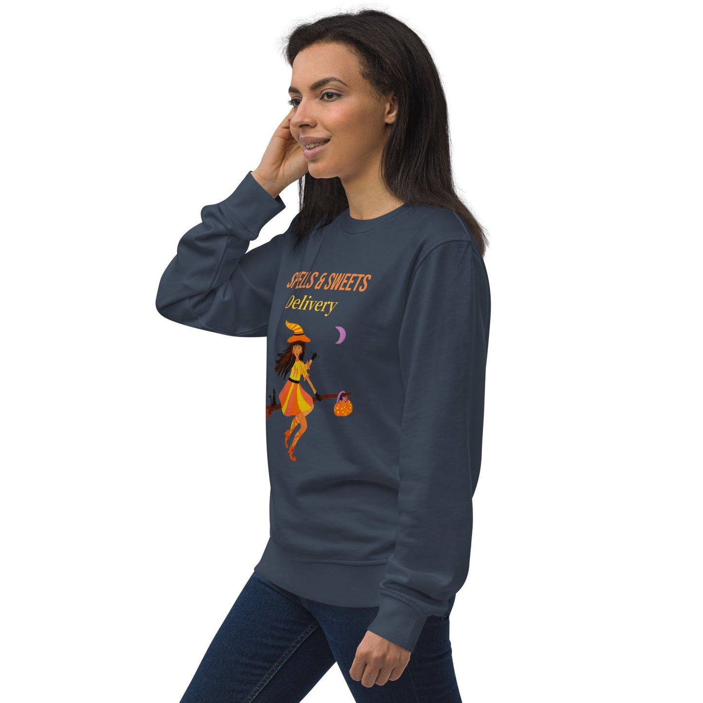 Woman wearing a dark blue sweatshirt with a 'Spells & Sweets Delivery' Halloween design on a white background