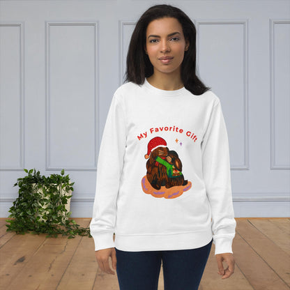 Woman wearing a white sweatshirt with a rabbit design in christmas theme and text 'my favorite gift' indoors.