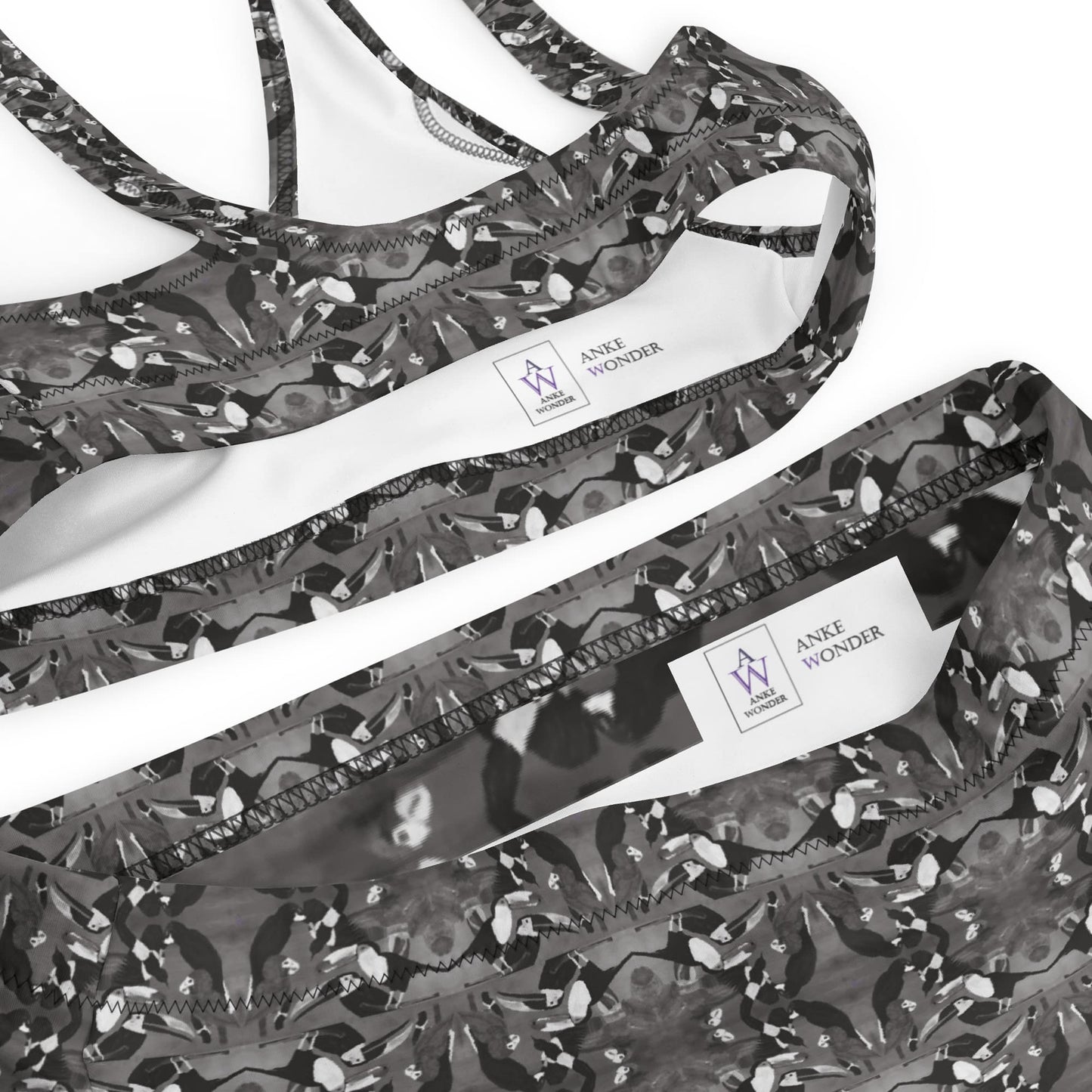 Black and white  bikini with tropical bird print and brand label Anke Wonder on a white background.