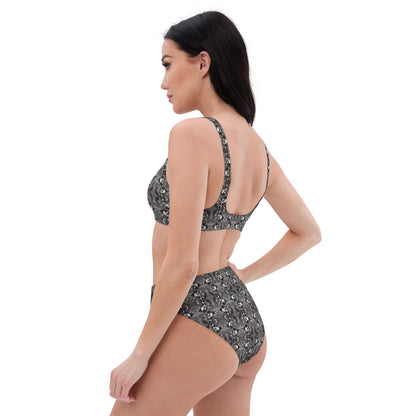 Left back view of woman wearing a black-white tropical bird bikini on a white background.