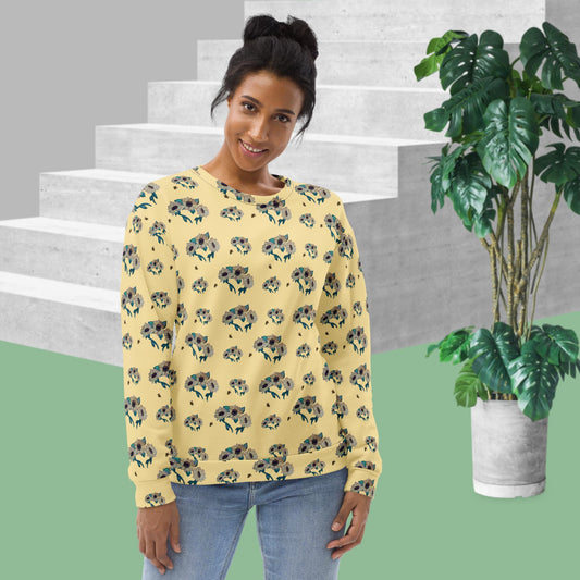 Woman wearing a yellow floral sweatshirt standing in front of a staircase with a plant in the background