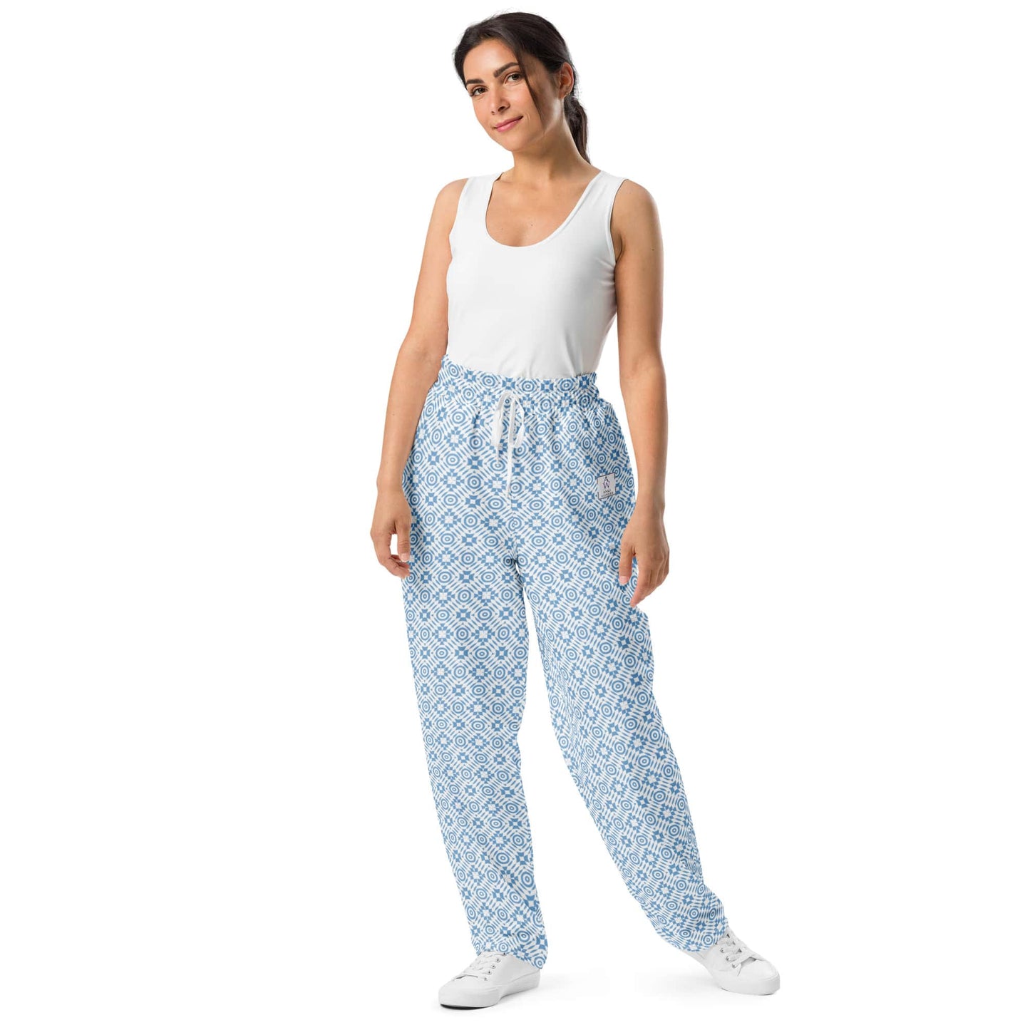 Model wearing wide-leg joggers with a blue geometric pattern, showcasing a relaxed fit made from recycled polyester.