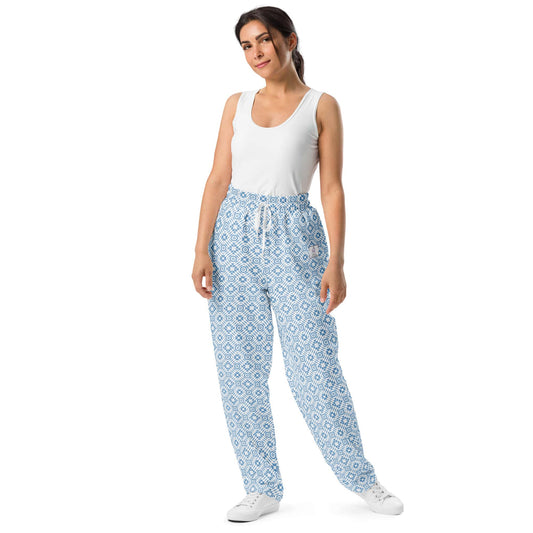 Model wearing wide-leg joggers with a blue geometric pattern, showcasing a relaxed fit made from recycled polyester.
