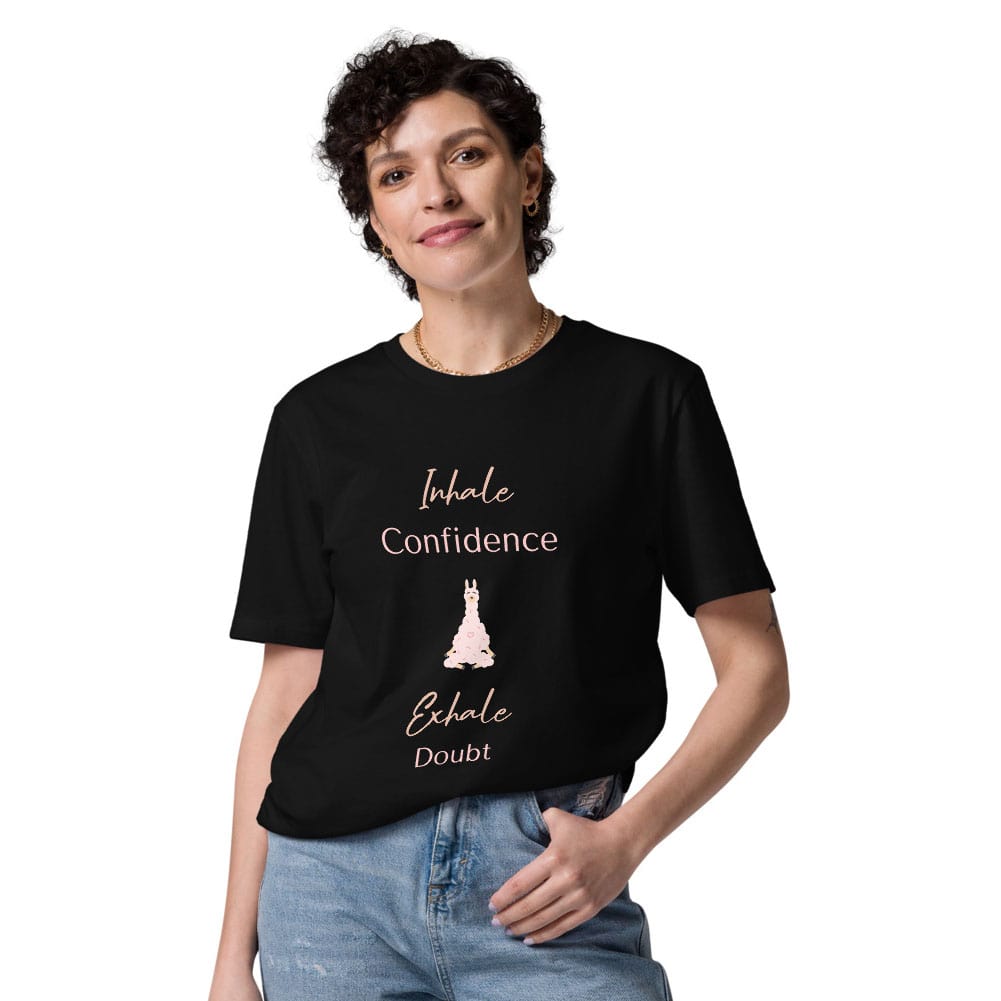 Woman wearing a black organic cotton t-shirt with "Inhale Confidence, Exhale Doubt" quote and a pink llama illustration.