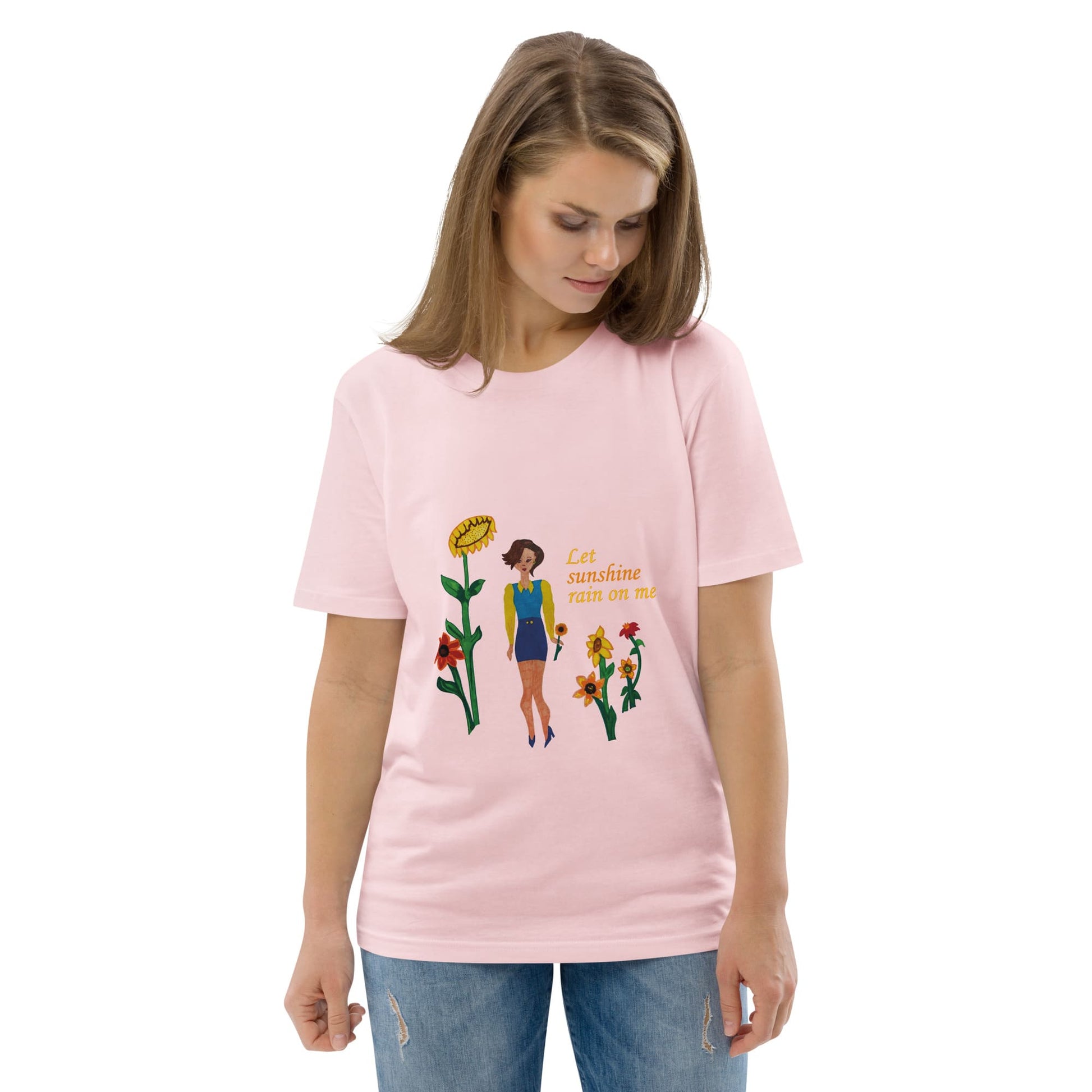 Woman wearing a pink t-shirt with a sunflower lady design and text 'Let sunshine rain on me' on a white background