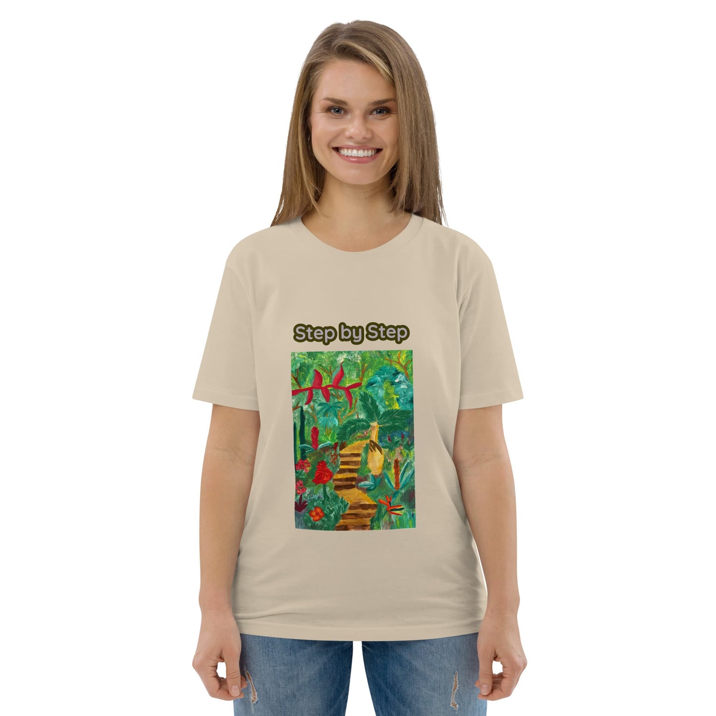 Woman wearing a beige t-shirt with a colorful graphic of lush tropics and a staircase and 'Step by Step' text on a white background