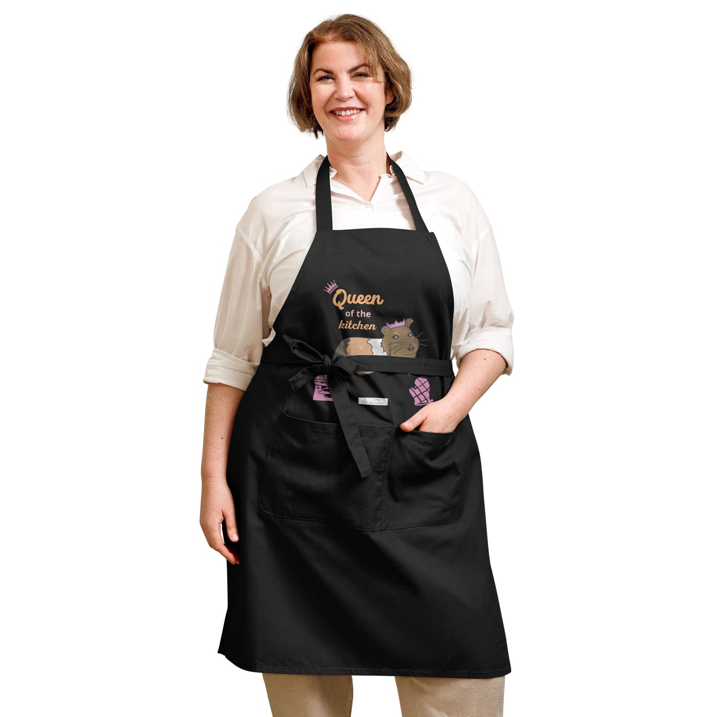 A plus-size woman wears a navy apron showing a guinea pig design with a crown and pink lettering.