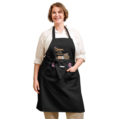 A plus-size woman wears a navy apron showing a guinea pig design with a crown and pink lettering.