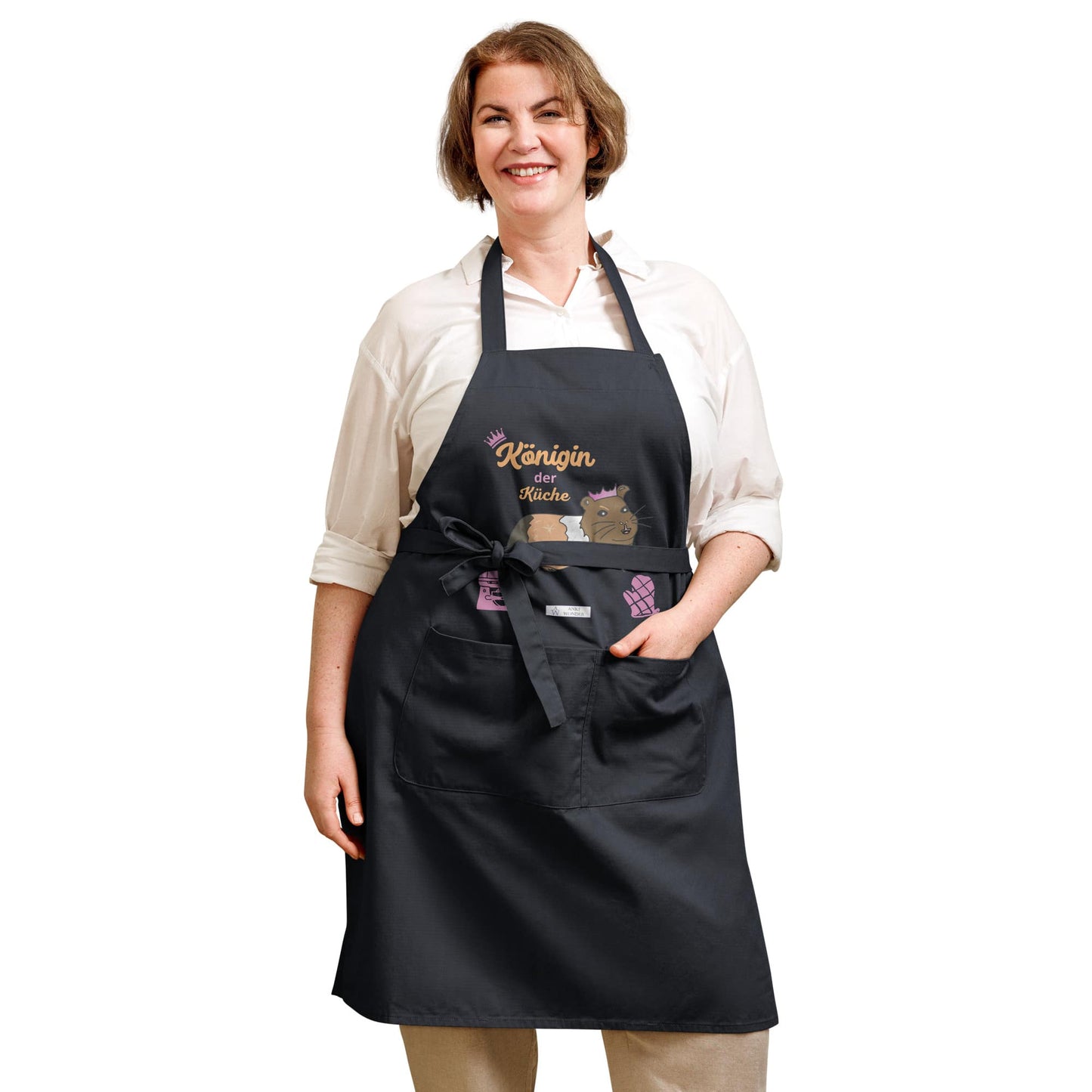 A plus-size woman models a navy apron with the playful guinea pig design and bold “Königin der Küche” text.