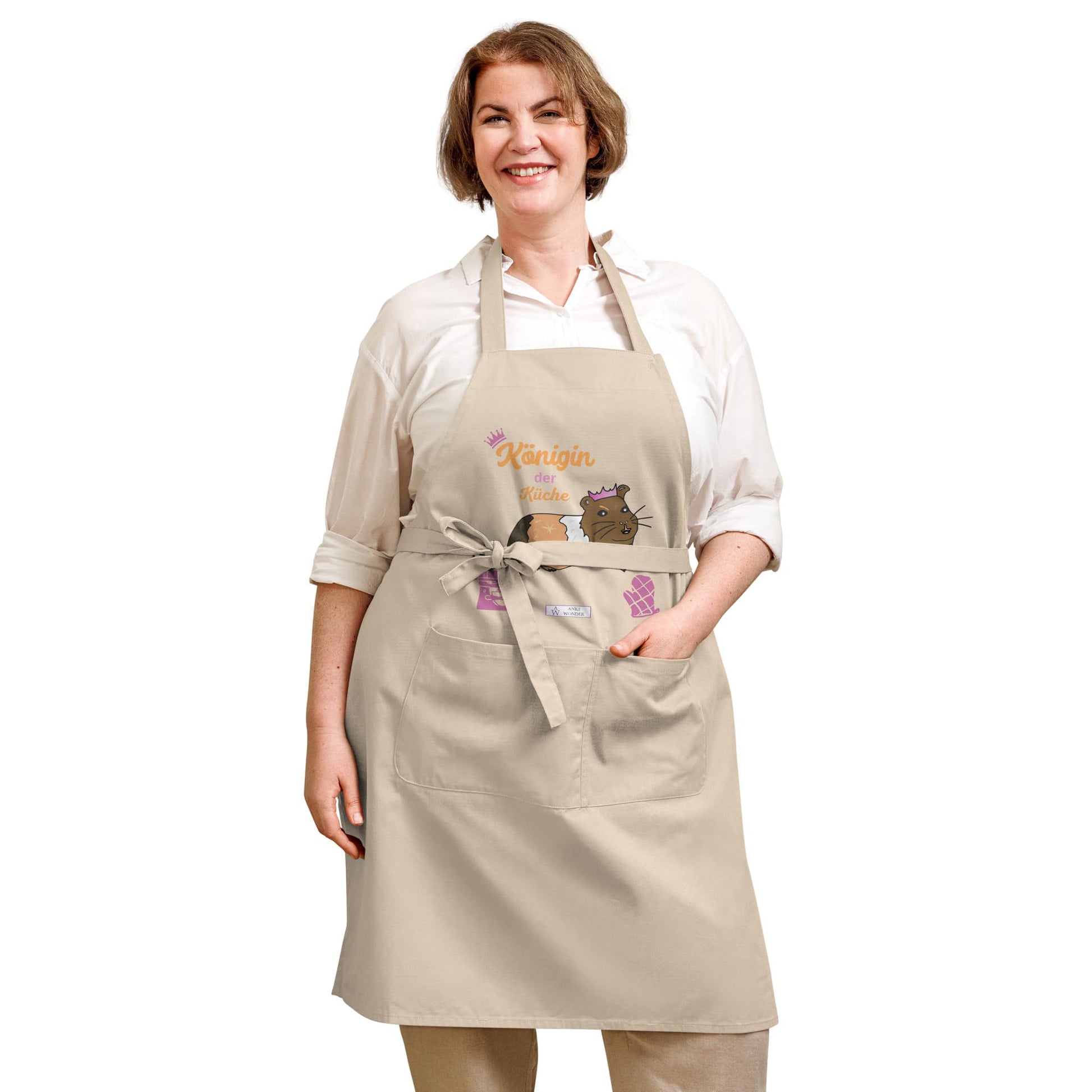 A plus-size woman models a natural apron with a guinea pig illustration and the playful “Königin der Küche” text.