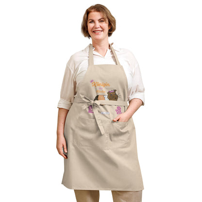 A plus-size woman models a natural apron with a guinea pig illustration and the playful “Königin der Küche” text.
