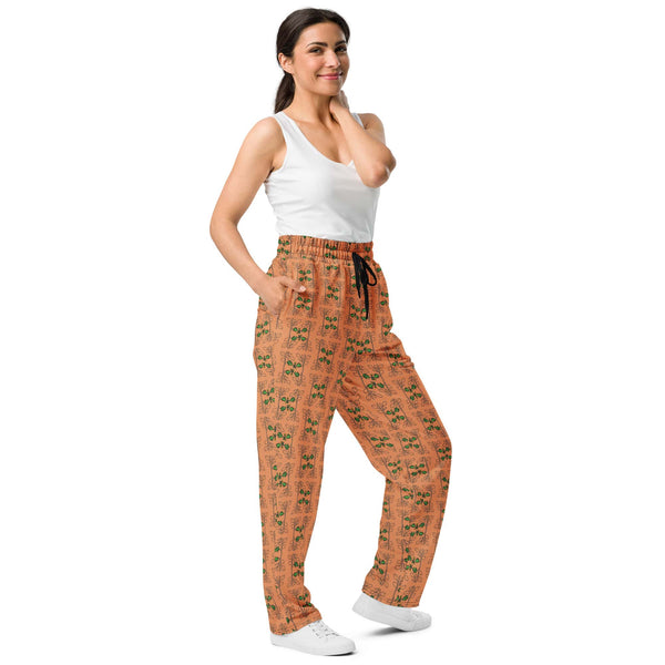 Front right view of a woman in orange joggers featuring a nature-inspired oak vine and acorn design, perfect for sustainable fashion lovers.