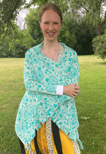 Women's mint-green cardigan with white cuffs and floral pattern shown from the front and closed. 