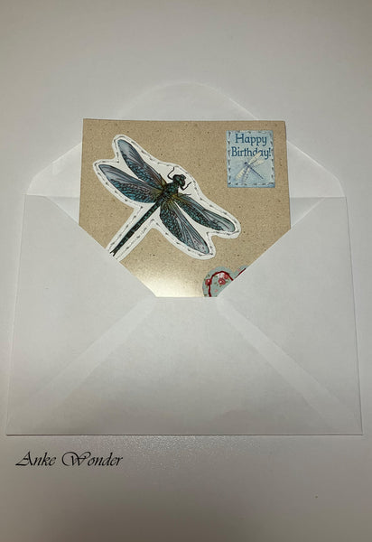 Handmade card with blue dragonfly in a white envelope.