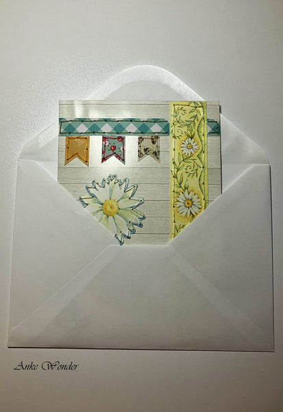 Handmade card with colorful pennant application in a white envelope.
